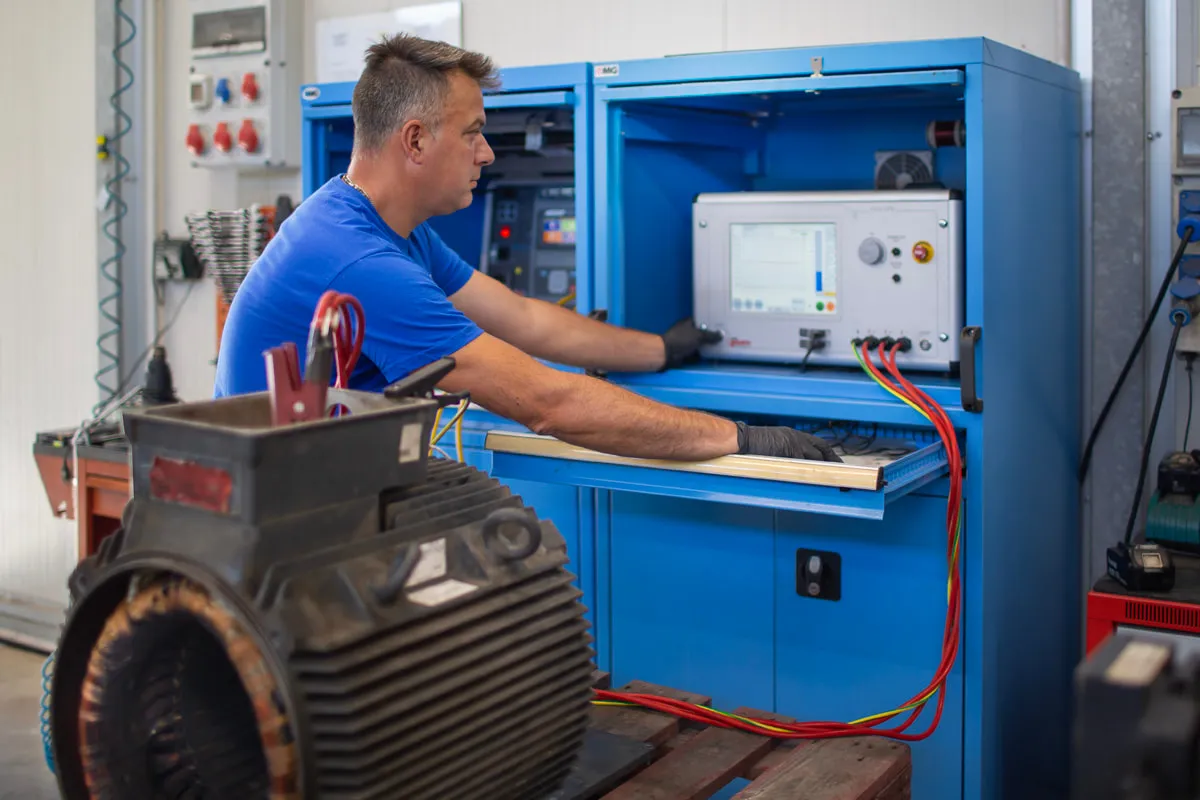Tecnico al banco prova per motori elettrici con quadro di controllo